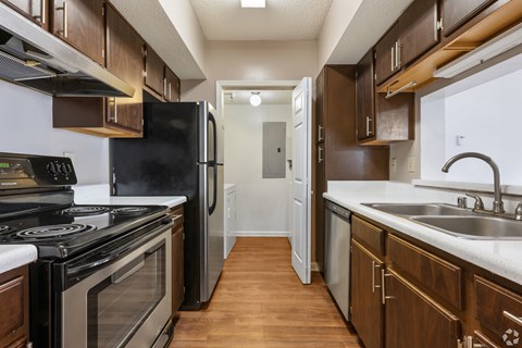 A kitchen with a black stove top oven and a black refrigerator.