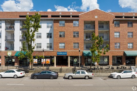 A building with a green awning and a sign that says "Waffle House" is in front of a tree.