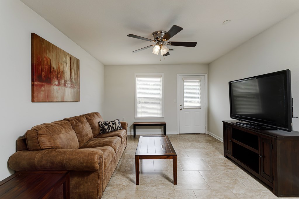 A living room with a brown couch and a television.