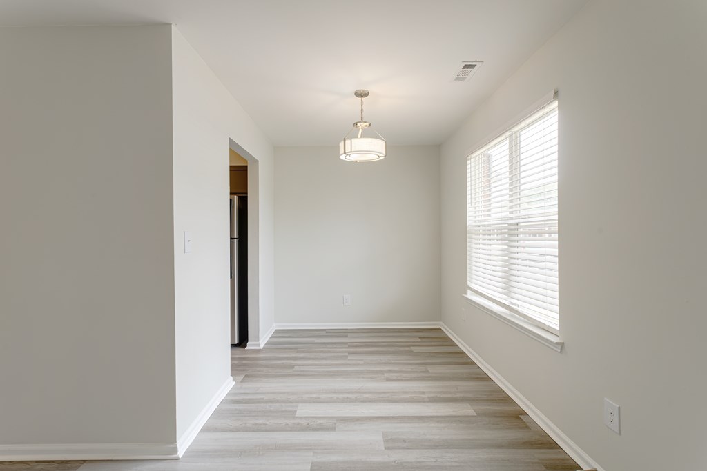 A room with a light on the ceiling and a door on the left.