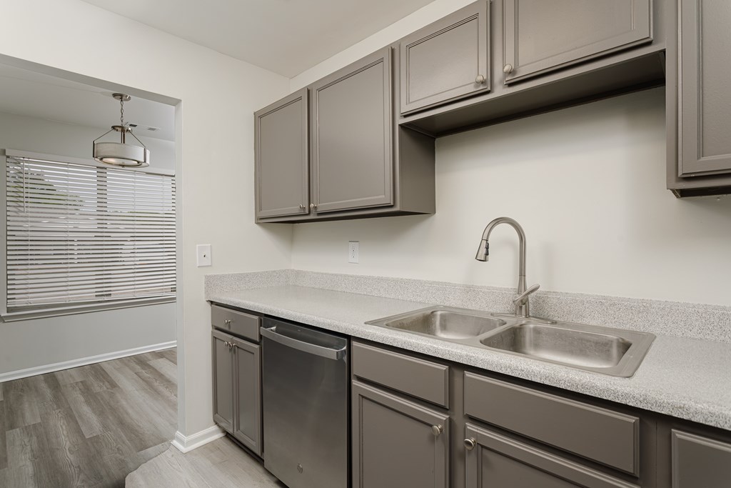 A kitchen with a stainless steel dishwasher and a sink.
