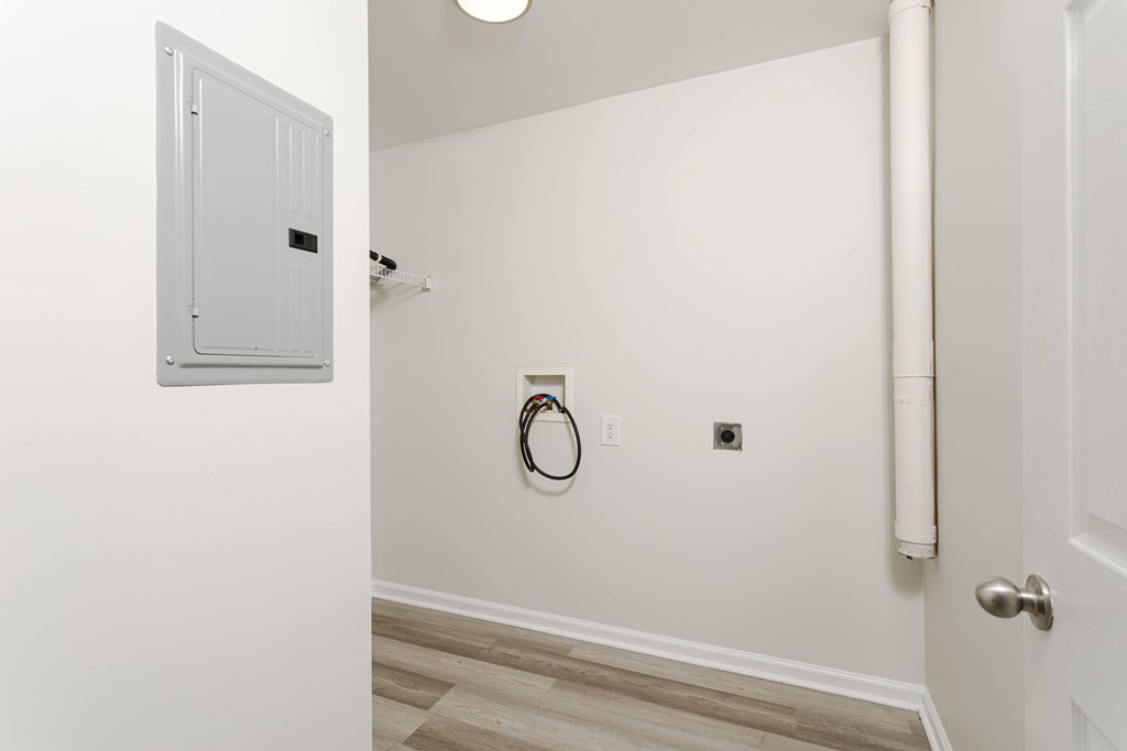 A white door is open to a hallway with a white wall and a white door.