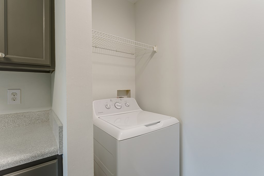 A white dryer is sitting in a small laundry room.