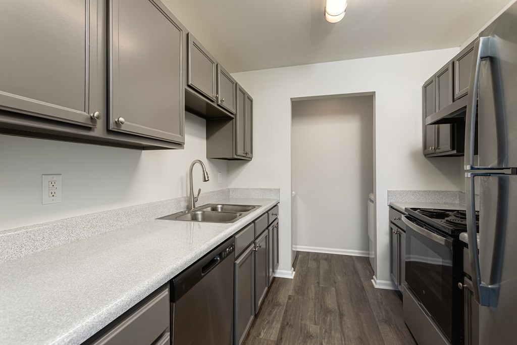 A kitchen with a sink, stove, and refrigerator.