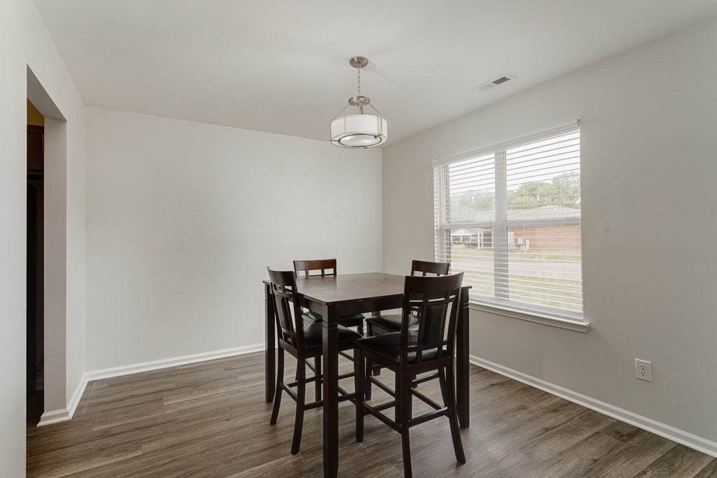 A dining room with a wooden table and chairs.
