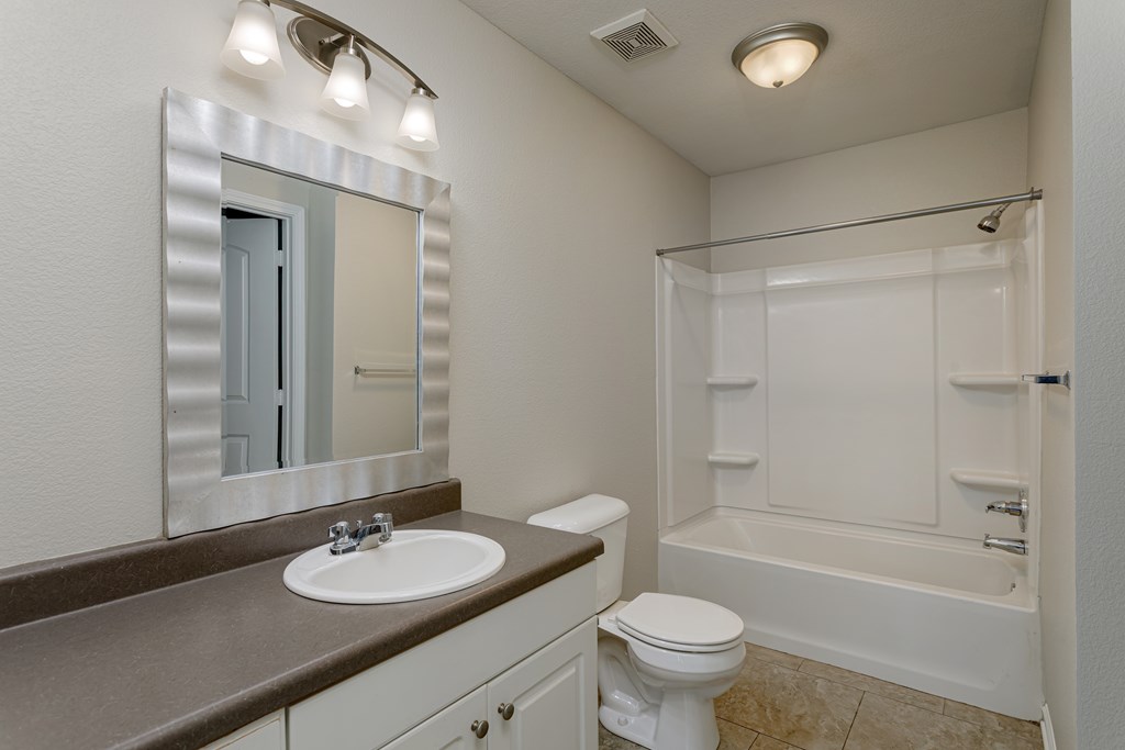 A white toilet sits next to a sink in a bathroom.