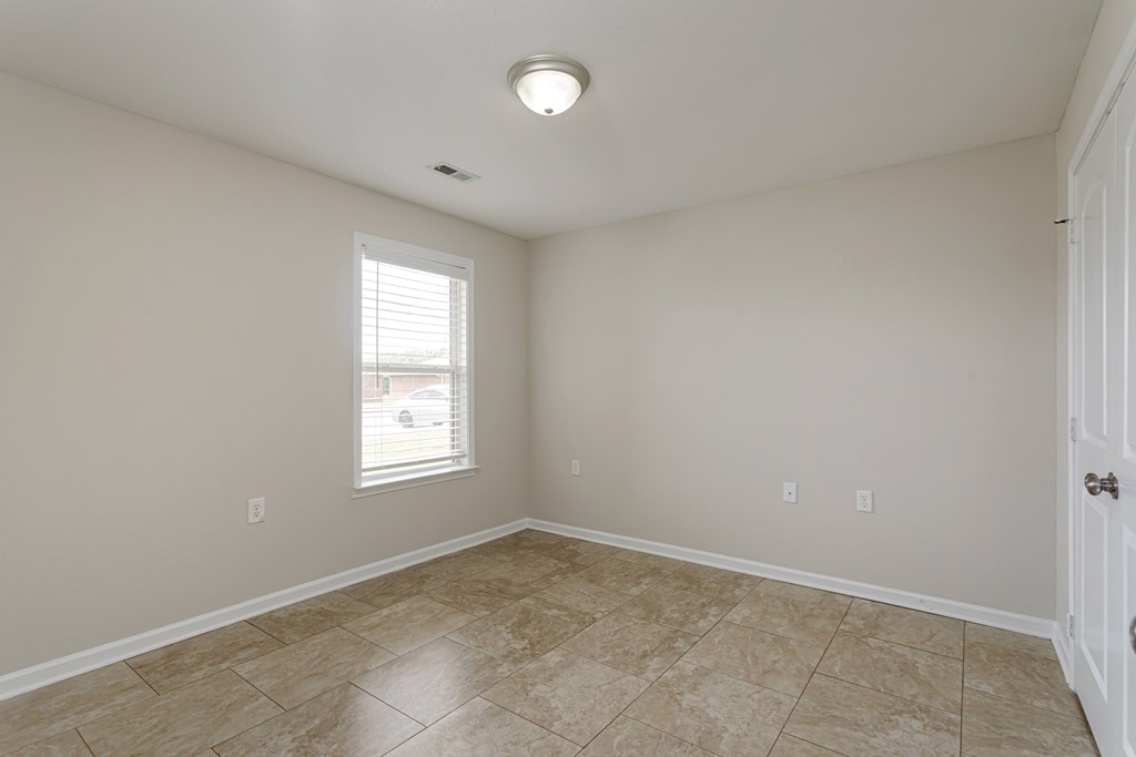 A room with a tiled floor and a window letting in light.