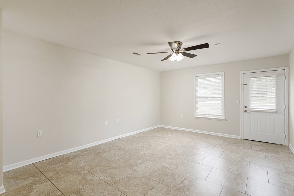 A room with a ceiling fan and tile flooring.