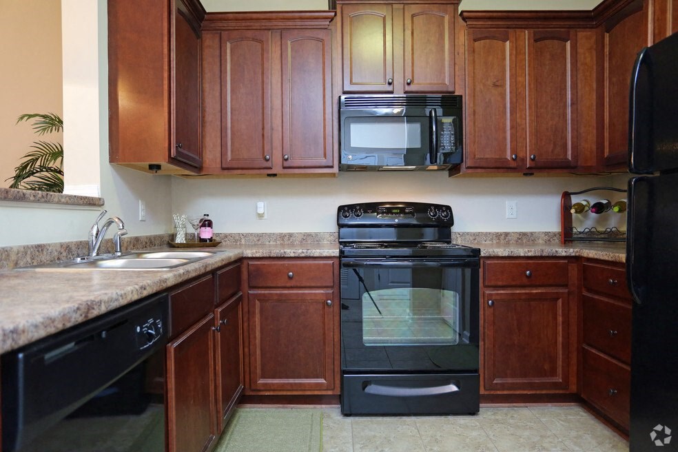 a kitchen with black appliances and wooden cabinets