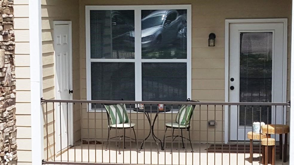 a patio with two chairs and a table on a porch