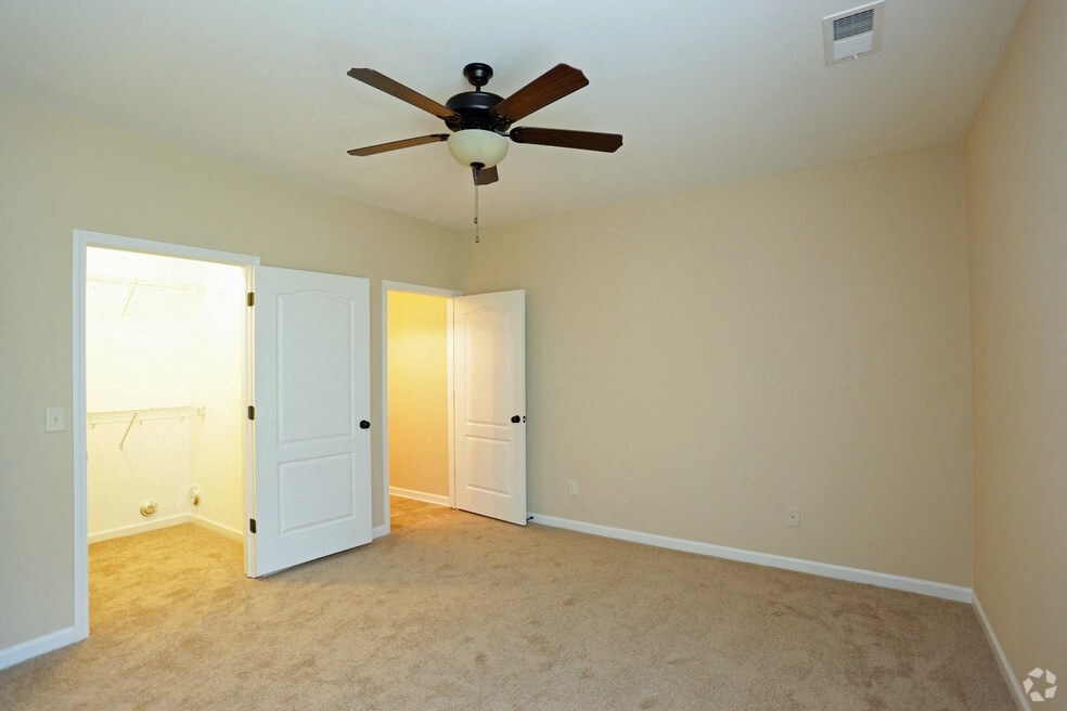 a empty living room with a ceiling fan