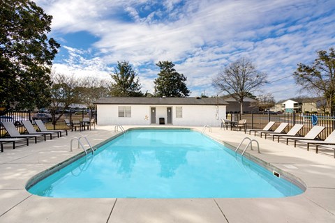 Swimming pool with sundeck and chaise lounges. A large outdoor swimming pool with chaise lounges at Magnolia Apartments in Athens, Alabama
