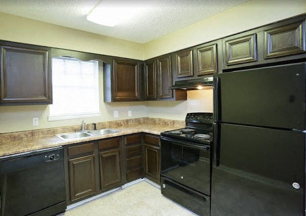 a kitchen with a black refrigerator and a sink