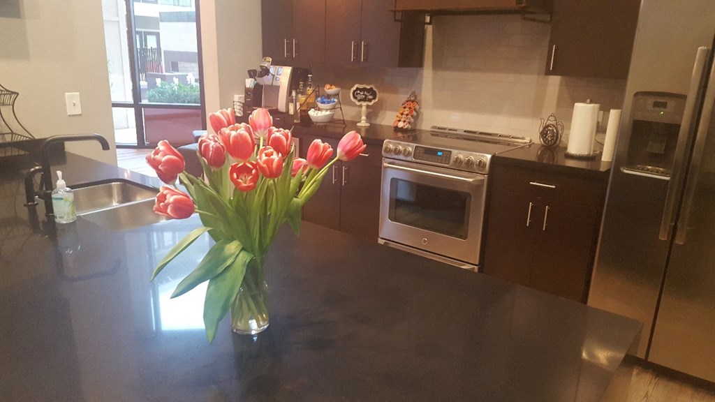 a vase of red tulips on a kitchen counter