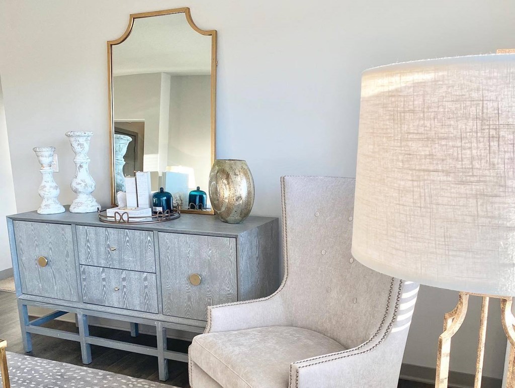 a dresser with a mirror and a chair in a living room
