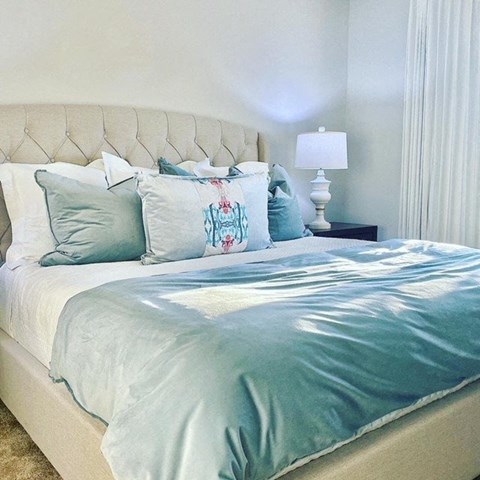a bed with blue and white pillows on it