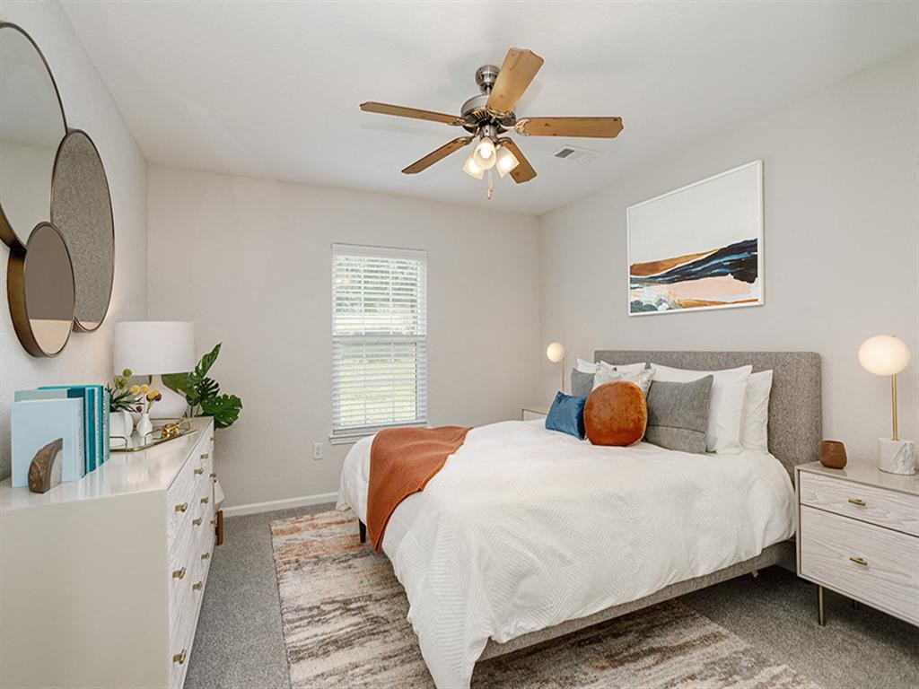 a bedroom with a bed and a ceiling fan