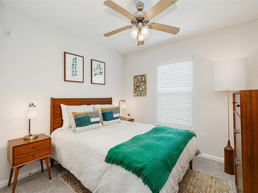 a bedroom with a bed and a ceiling fan