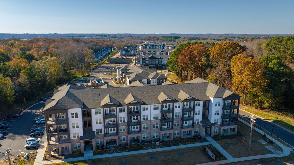 an aerial view of a large apartment building with trees in the background
