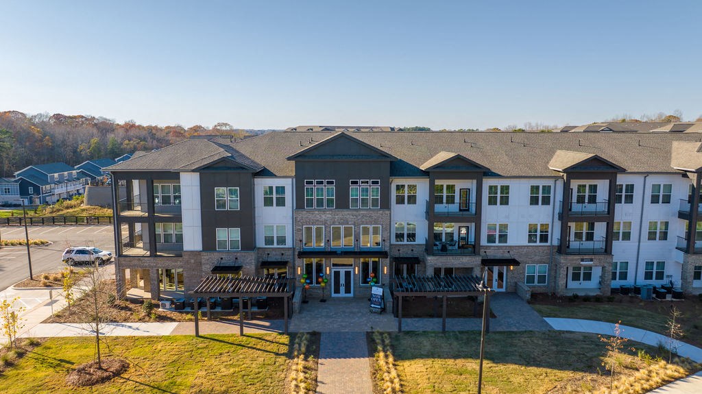 an aerial view of an apartment building with a parking lot
