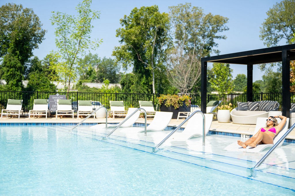 a woman relaxing in the pool at the resort on a sunny day
