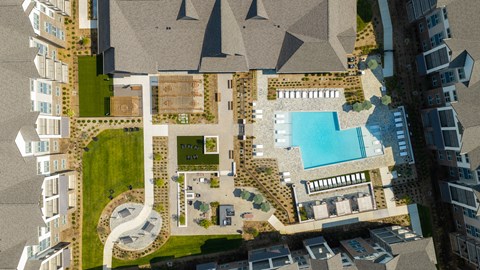 A bird's eye view of a residential area with a swimming pool.