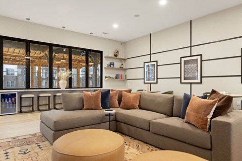 A living room with a grey couch and a large window.