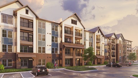 A modern apartment complex with cars parked in front.