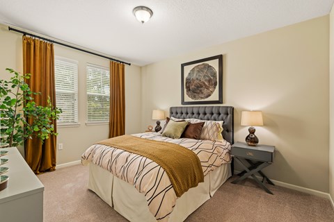 A bedroom with a large bed and a potted plant.