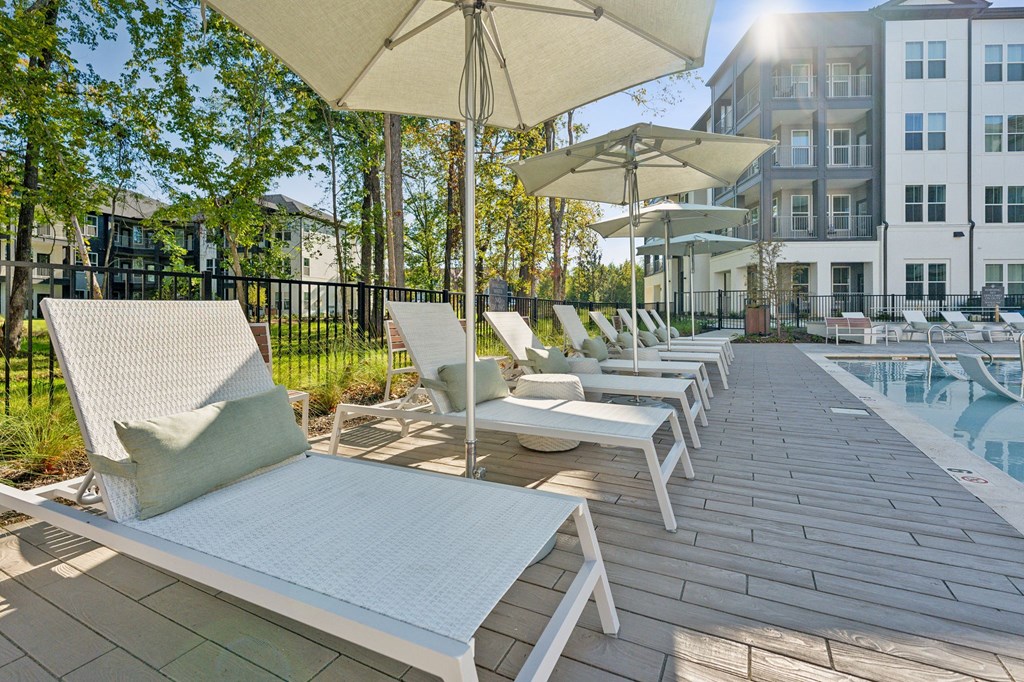 a group of lounge chairs on a deck next to a pool