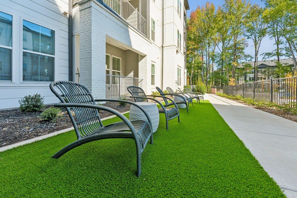 a row of benches on the grass in front of a building