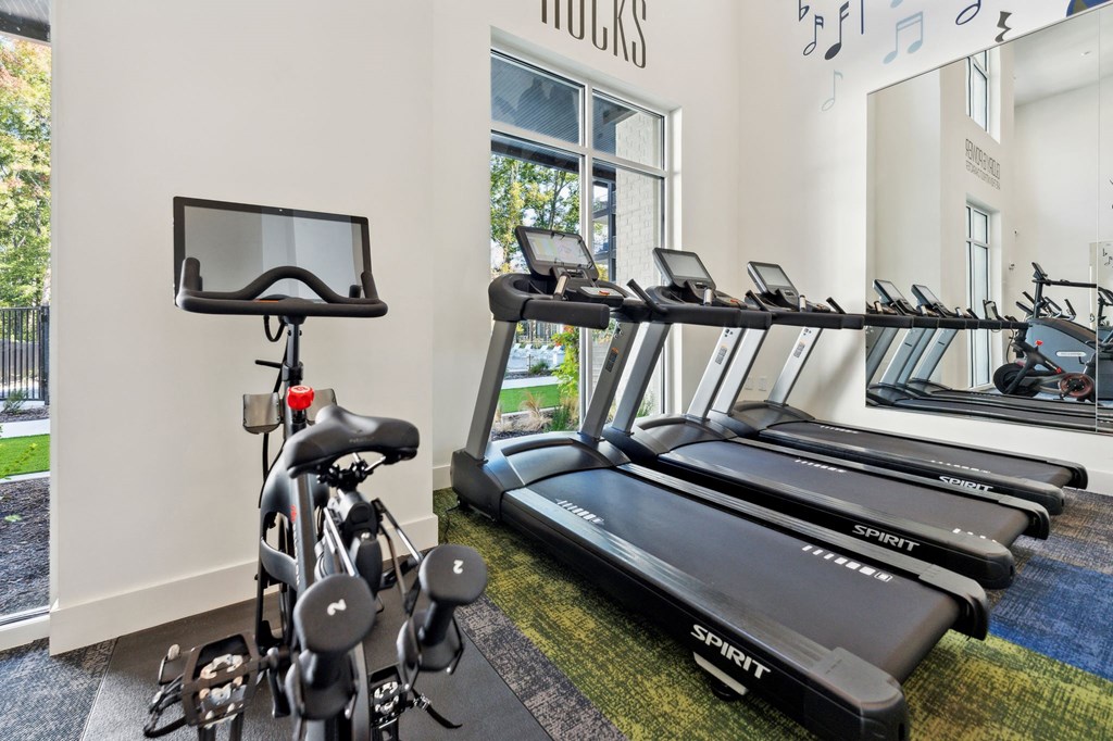 the gym with treadmills and weights at the district flats apartments
