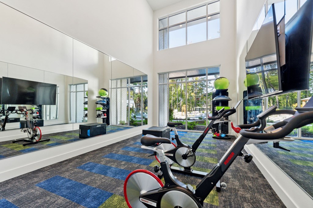 a gym with exercise equipment and large windows