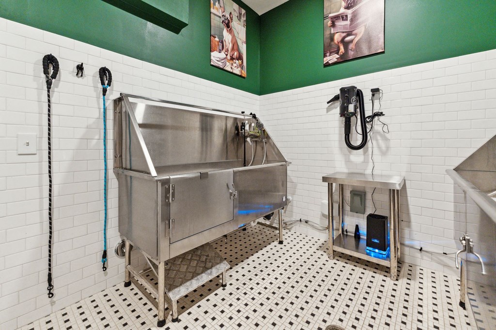 a stainless steel sink in a bathroom with green walls