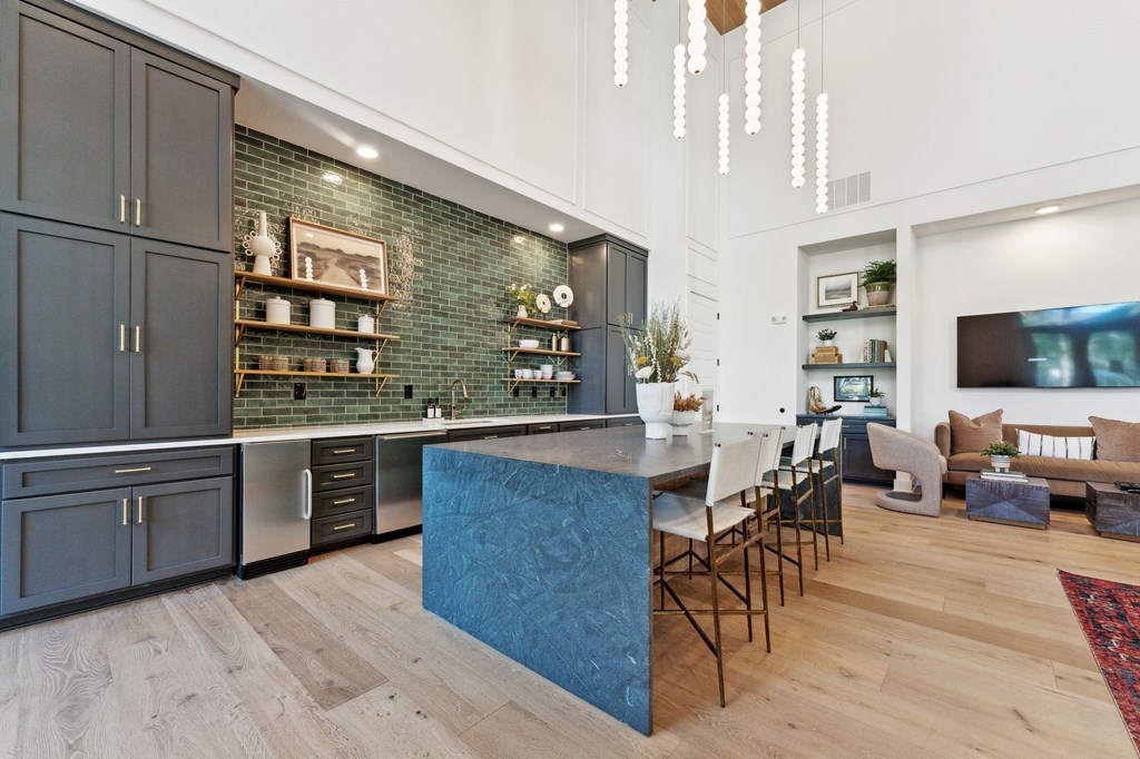 a kitchen with a blue island and a living room with a table and chairs