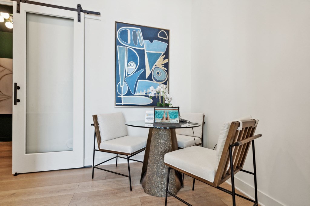 a dining room with a table and chairs and a painting on the wall