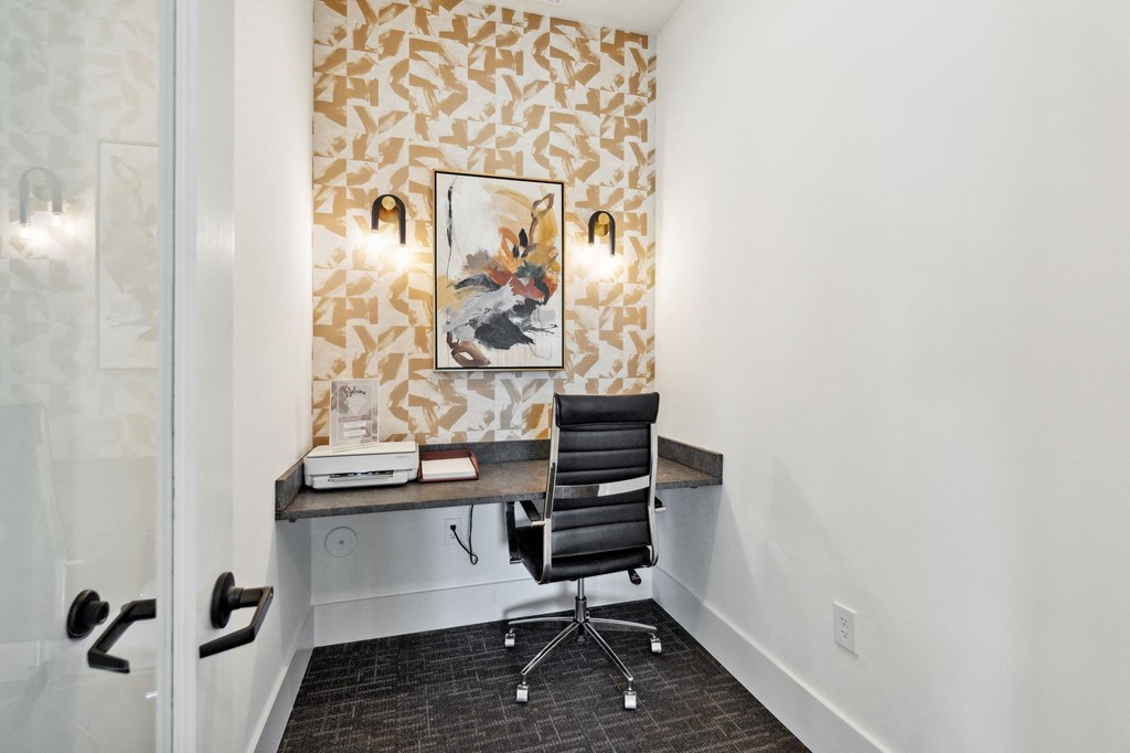 a desk in a room with a chair and a painting on the wall