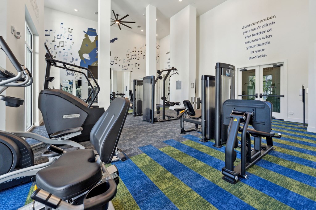 a gym with treadmills and other exercise equipment in the lobby of a building