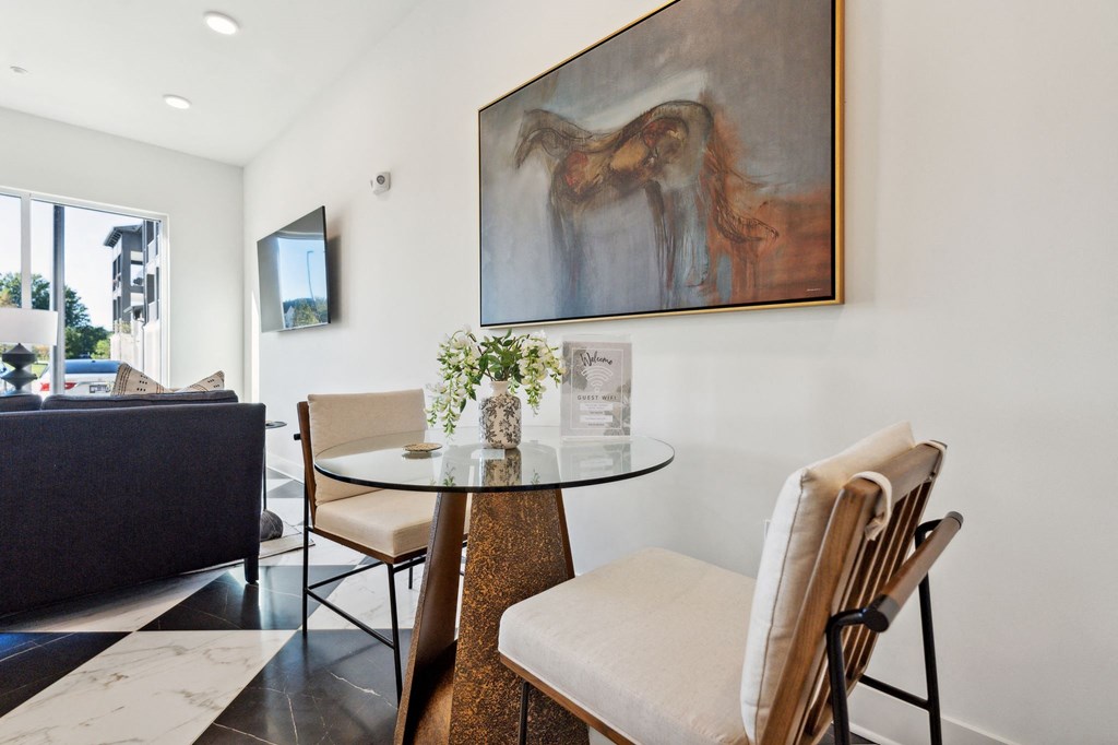 a dining room with a table and chairs and a painting on the wall
