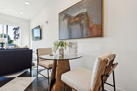 a dining room with a table and chairs and a painting on the wall