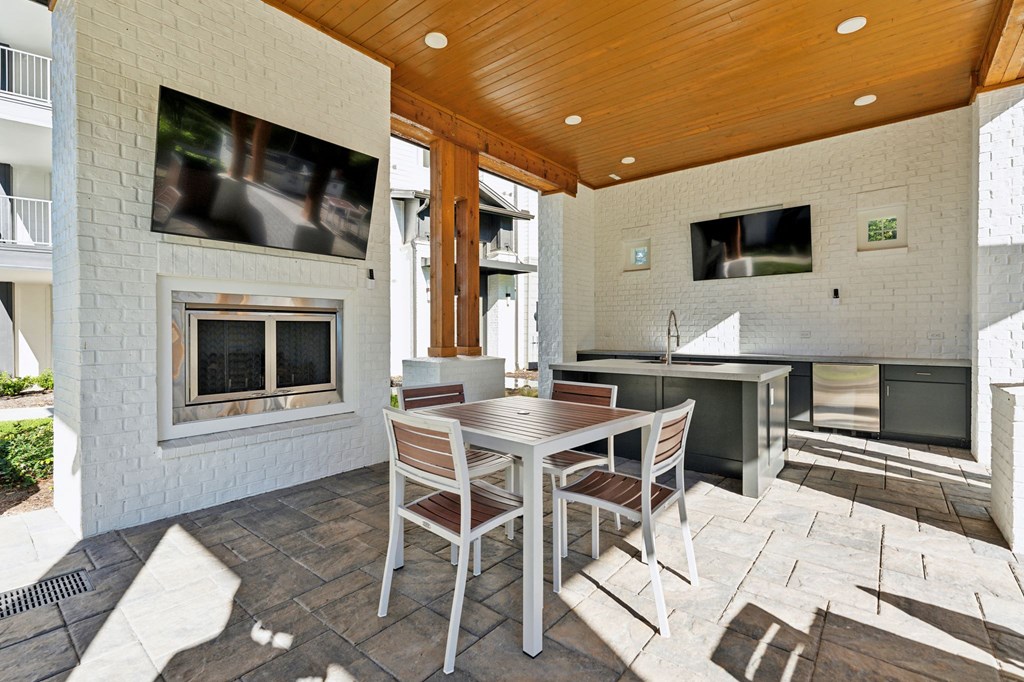 a patio with a table and chairs and a fireplace
