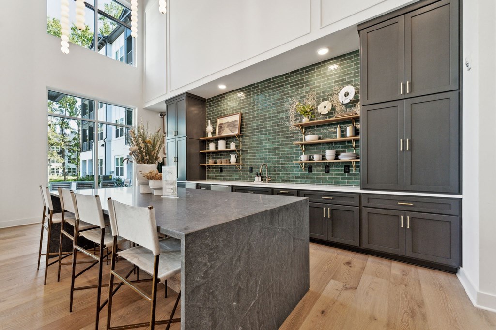 a kitchen with black cabinets and a marble counter top