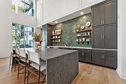 a kitchen with black cabinets and a marble counter top
