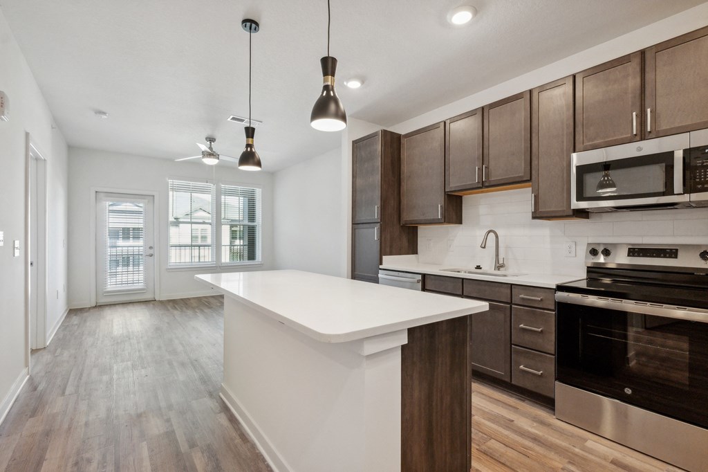 an open kitchen with a large white counter top in a new home