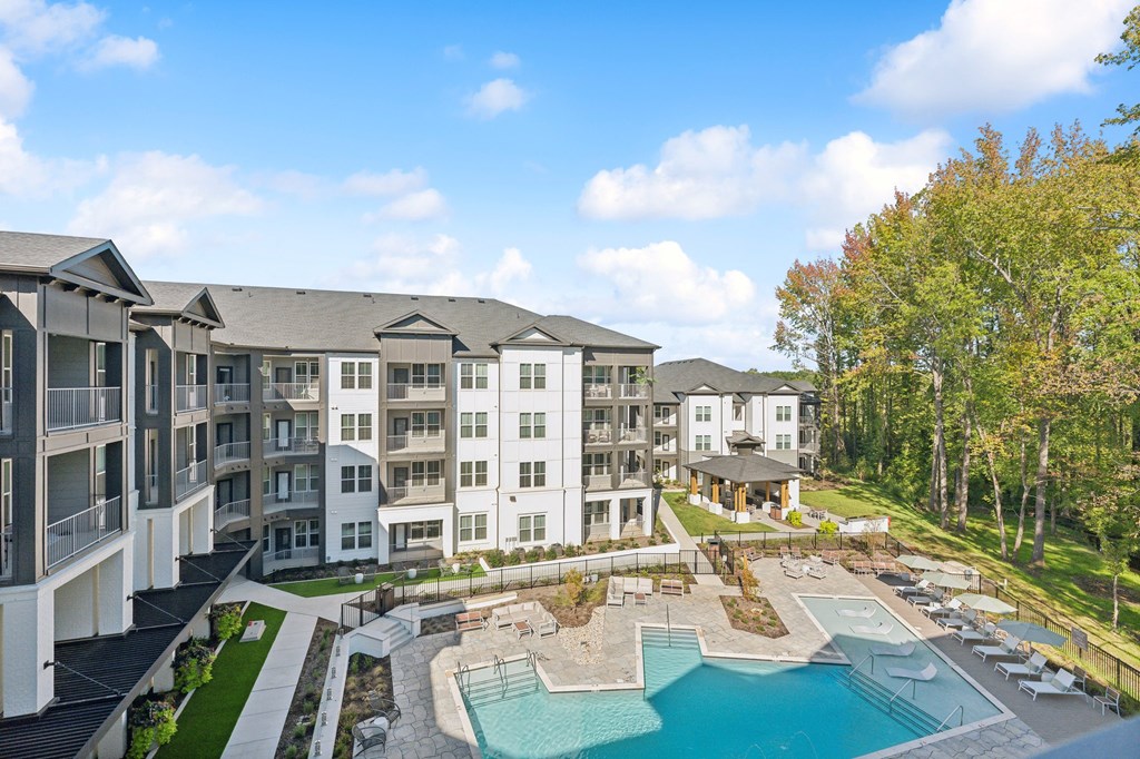 an aerial view of an apartment complex with a swimming pool and a poolside patio