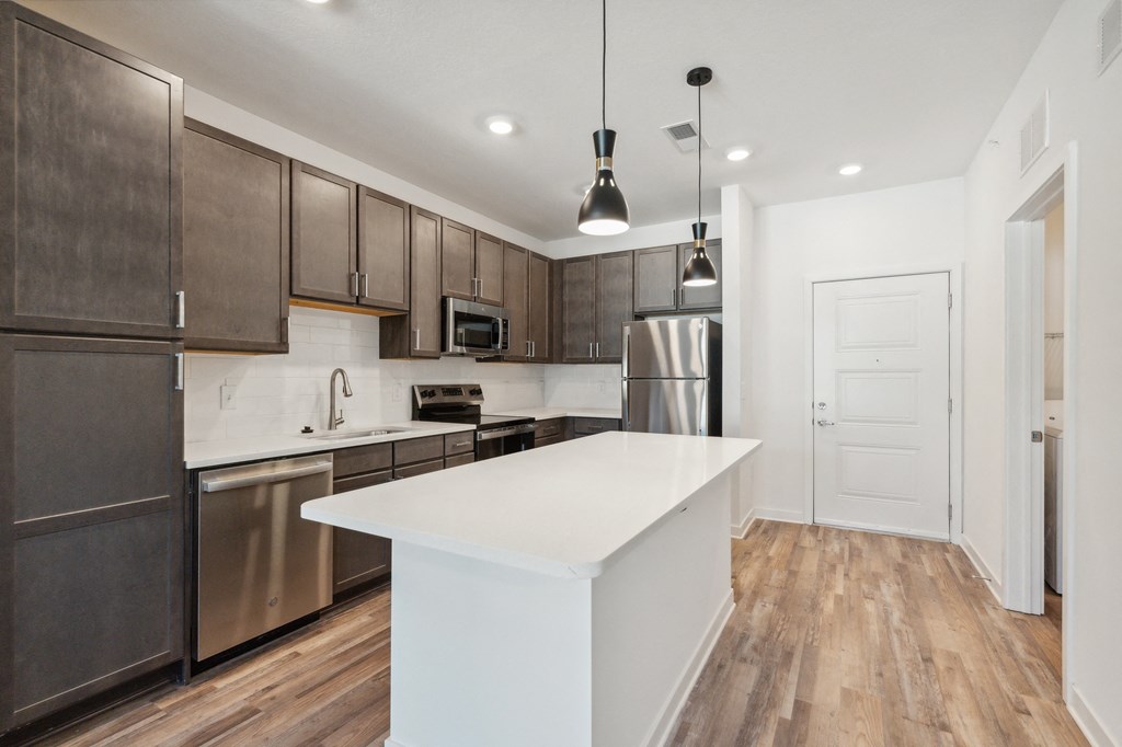 a white kitchen with stainless steel appliances and a white counter top