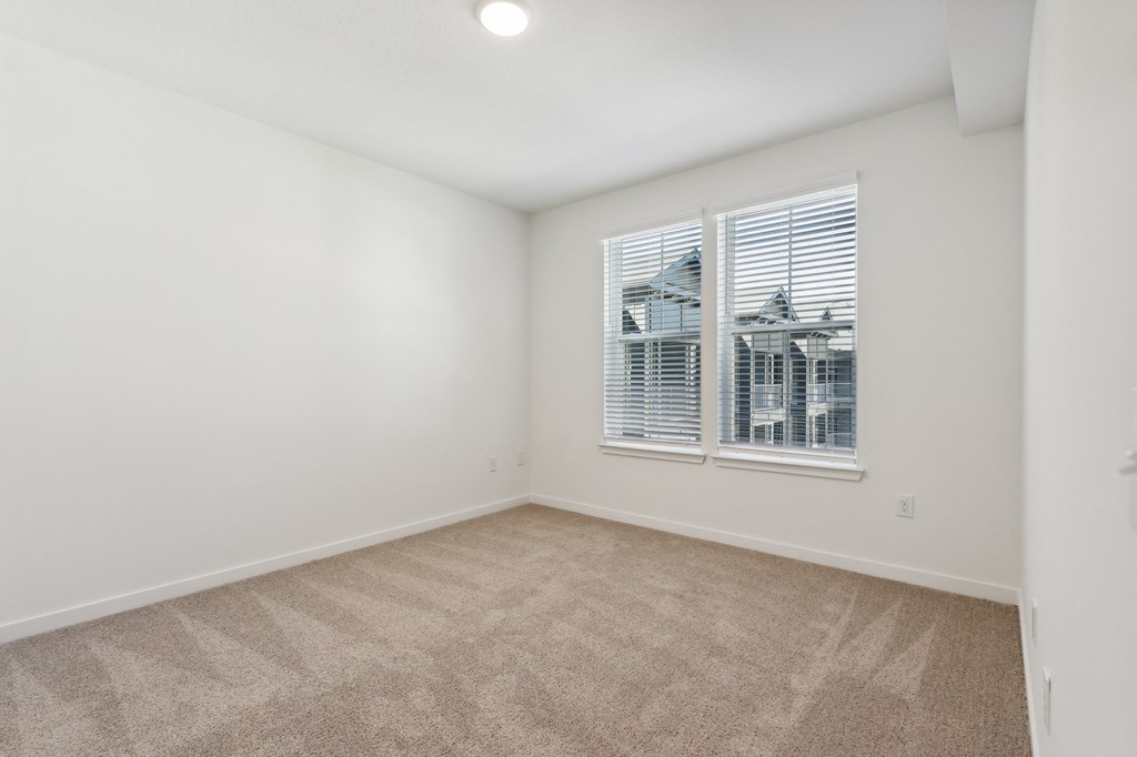 an empty room with carpet and a window