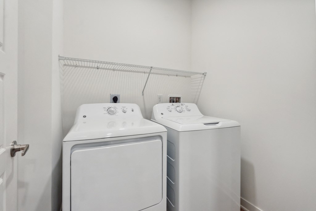 a white washer and dryer in a white laundry room