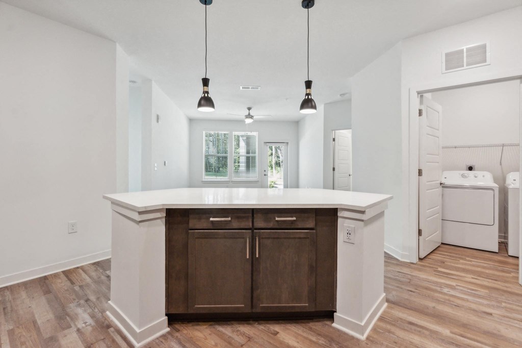 a white kitchen with wooden floors and a white counter top