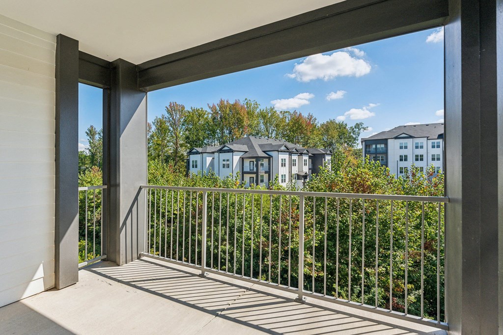 a balcony with a view of trees and houses in the distance